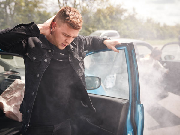 a young man exits his car injured after